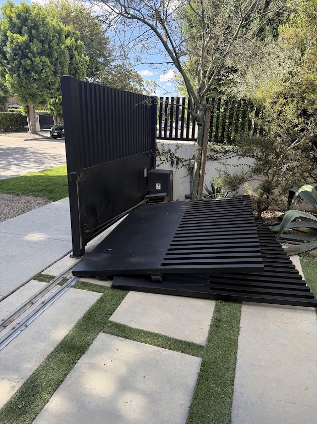 Gate Repair in Sherman Oaks, CA 3 A sliding driveway gate off its track, lying on the paver walkway beside the opening